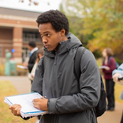 Earth and Environmental Sciences student outside recording data